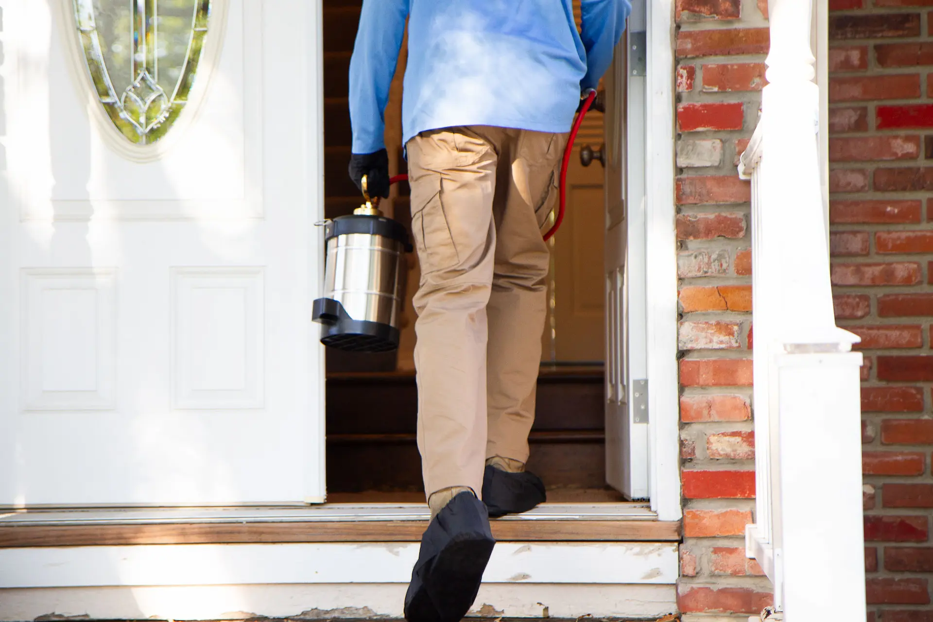 a pest control technician entering a home in Platte City
